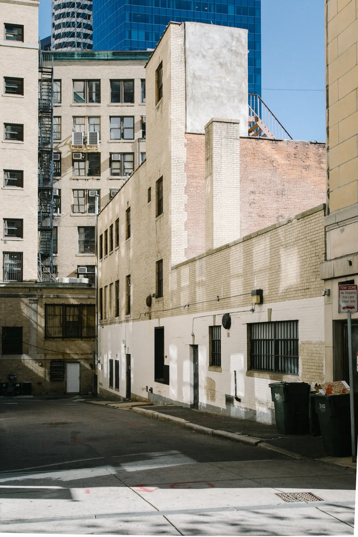 Blank brick wall of a low building between taller blocks