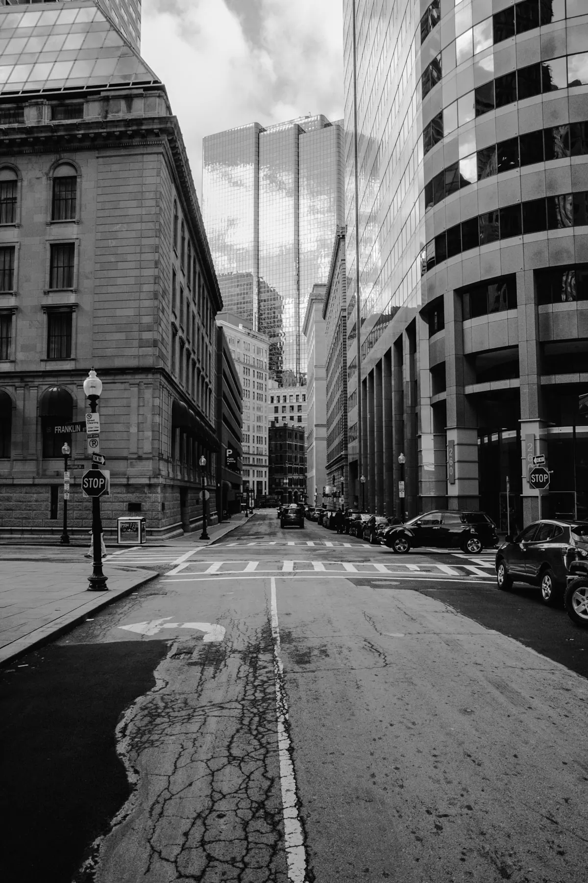 Empty street between tall bank buildings, a stop sign on either side