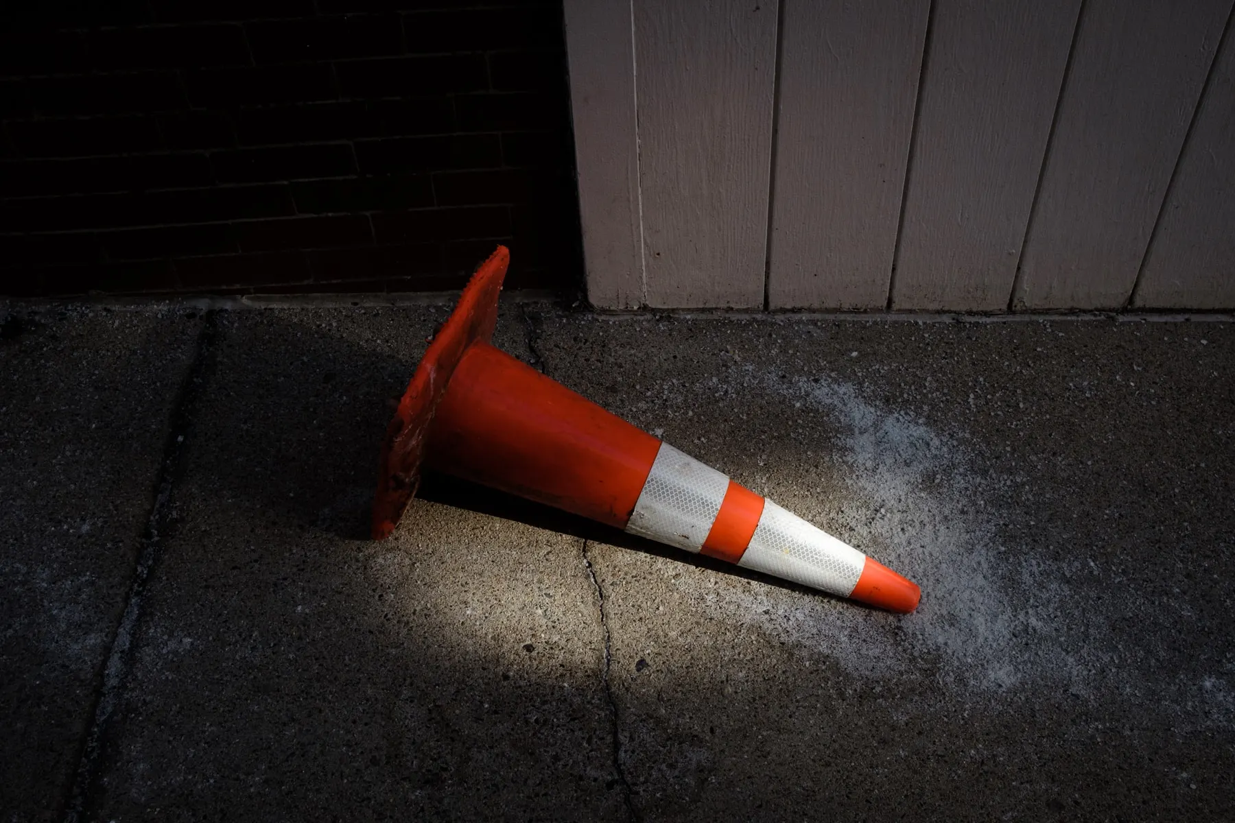 Cone lying on its side against a dark wall