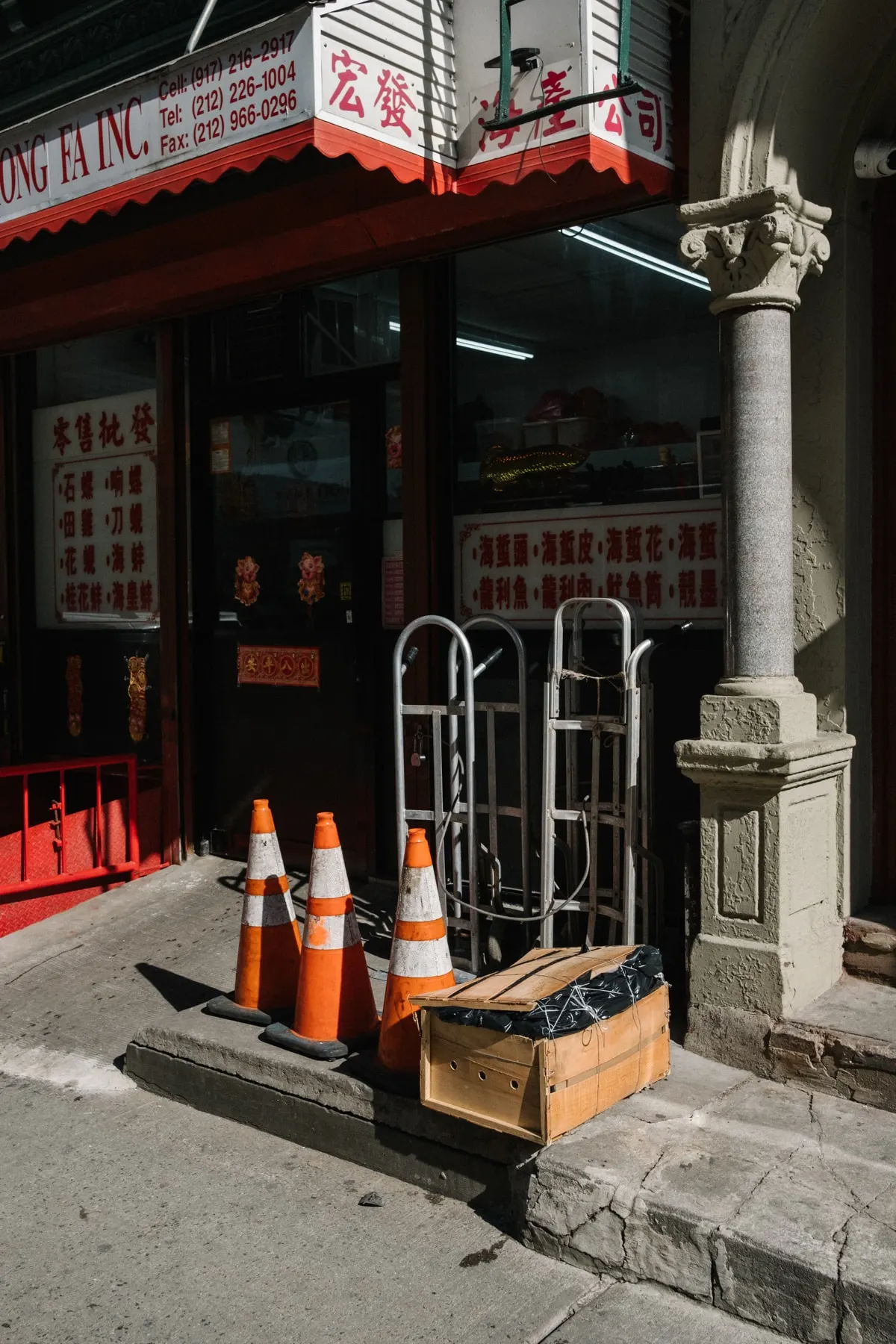 Cones and hand trucks outside a Chinatown shop