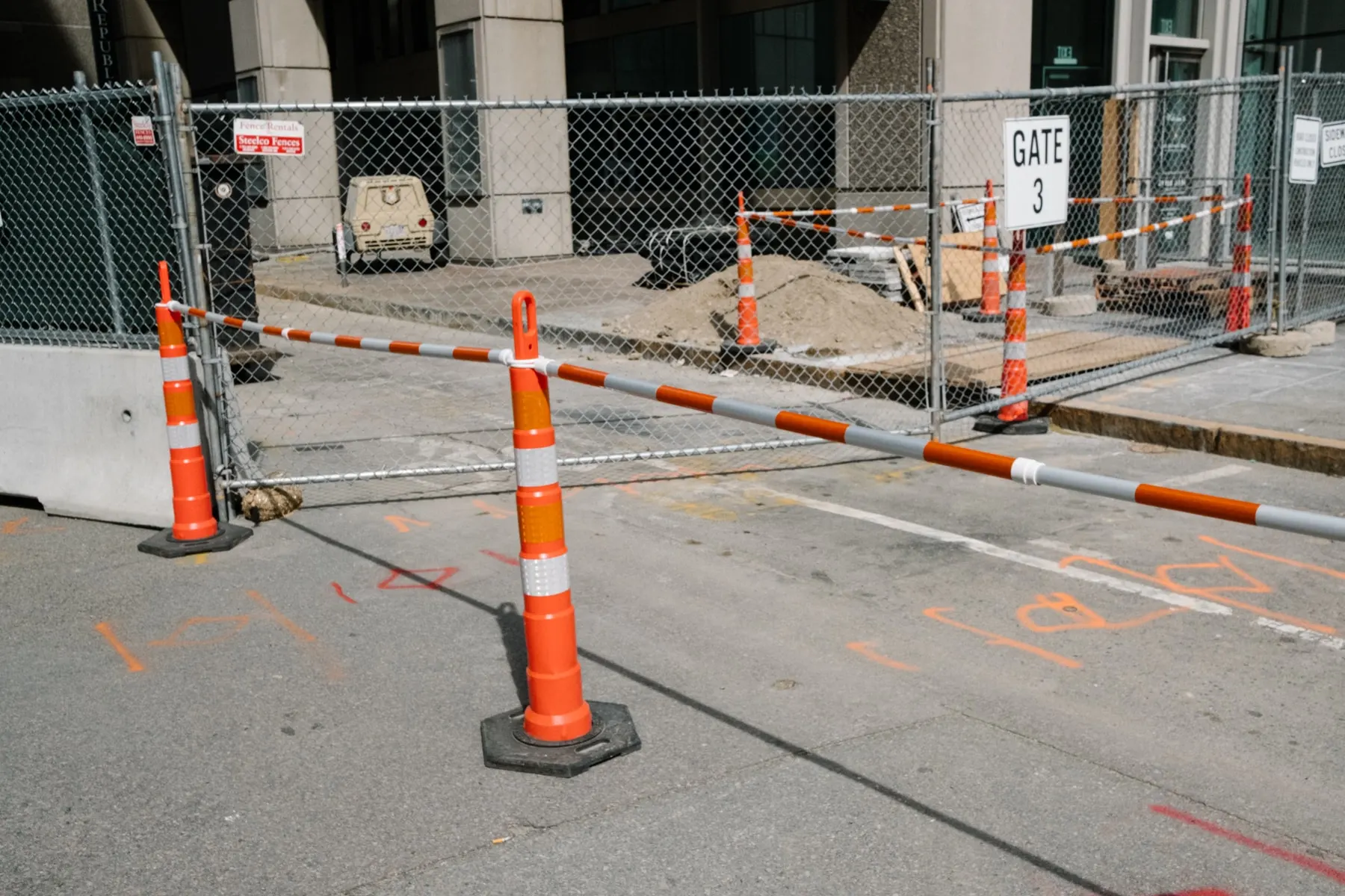 Cones and barrier poles around a fenced building site