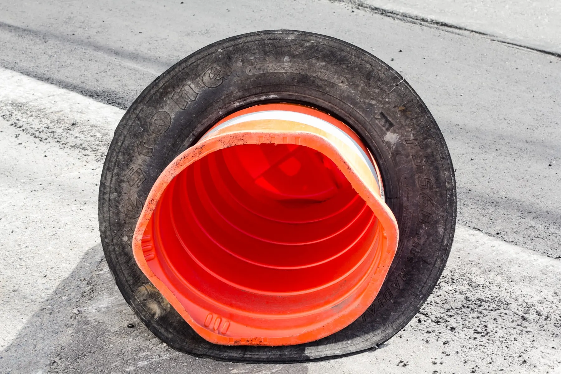 Cone sitting inside a tyre lying in the road